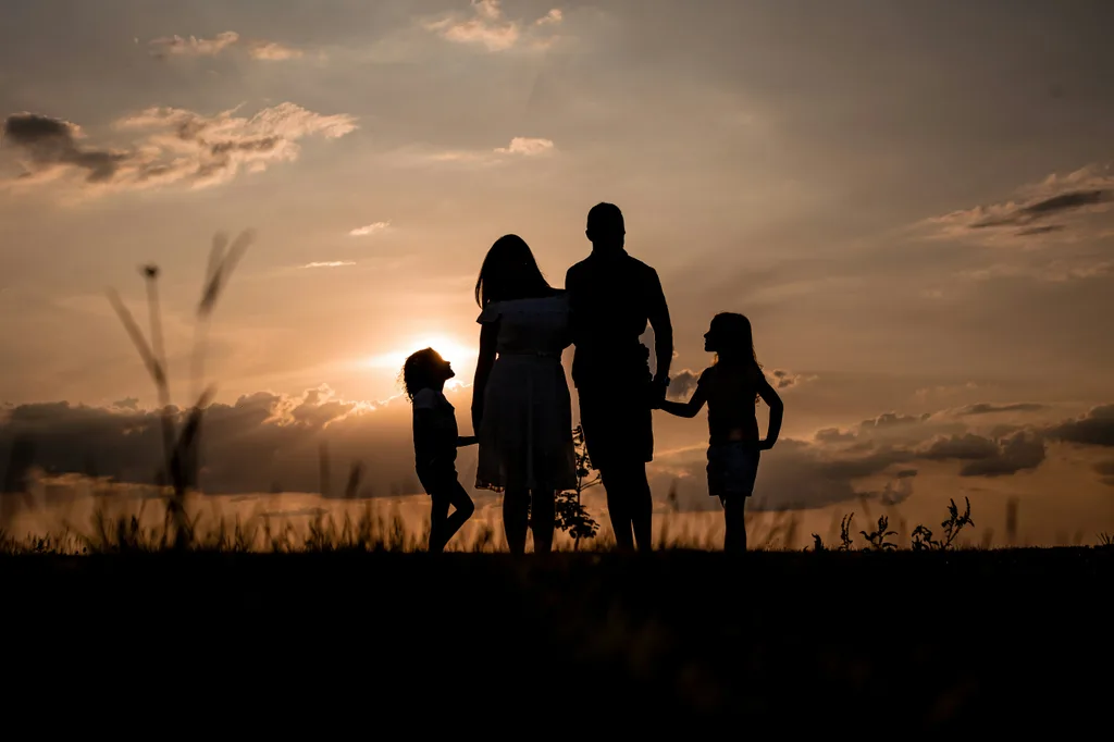 Silhouette of a family enjoying a sunset together outdoors